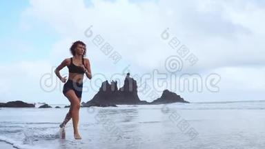 早上，穿着运动服的漂亮女运动员沿着大西洋海岸跑步。 健康的概念